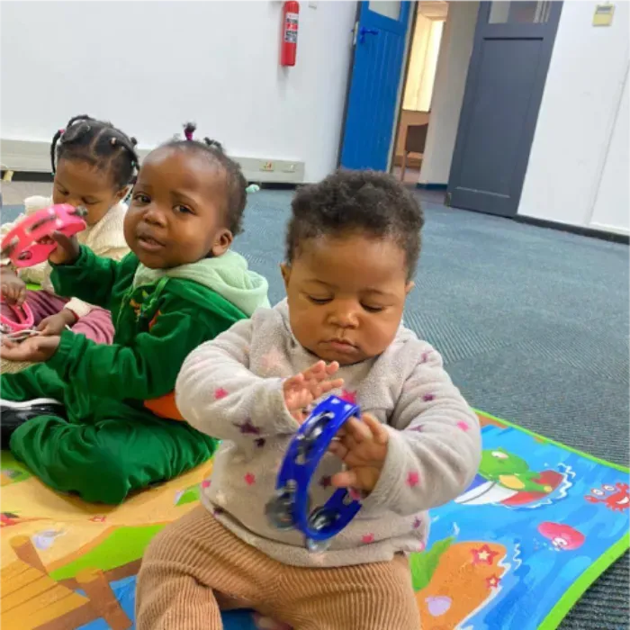 Toddlers playing tambourines during music time